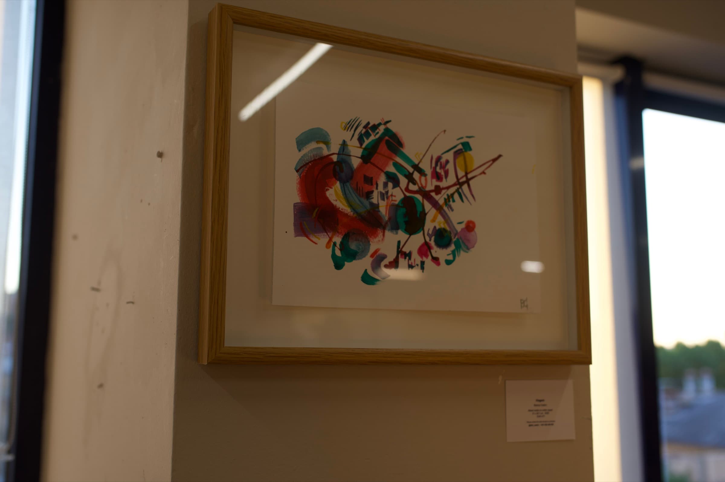Framed mixed media work by Bianca Castro beside a window at Creative Rez